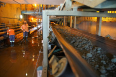 Workers mend a pipe as crushed ore is transported on a conveyor belt at the Kibali gold mine Haut-Uele province, Democratic Republic of Congo October 8, 2021.