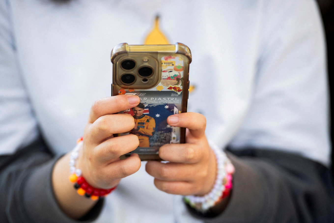 A person poses while holding a mobile phone, in Sydney, Australia on July 14, 2026.