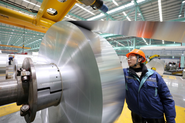 A worker checks an aluminum sheet roll on Feb. 11, 2025, at an aluminum processing factory in Huaibei, Anhui, China.