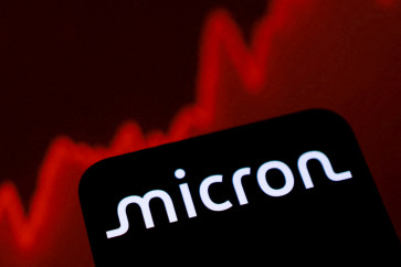 The&nbsp;logo of United States-based chipmaker Micron&nbsp;Technology and a rising stock graph are pictured on June 11.