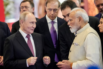 This handout photograph taken and released by the Indian Press Information Bureau (PIB) on September 11, 2026 shows India's Prime Minister Narendra Modi (right) speaking with Russia's President Vladimir Putin at an exhibition during the BRICS Business Forum 2026 in New Delhi. 
