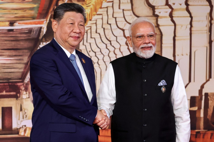 In this pool photograph distributed by the Russian state agency Sputnik, India's Prime Minister Narendra Modi (right) shakes hands with China's President Xi Jinping during a welcome ceremony before the start of the 18th BRICS Summit in New Delhi on September 12, 2026. 