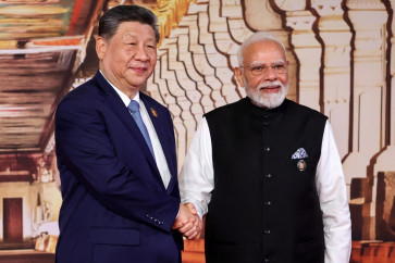 In this pool photograph distributed by the Russian state agency Sputnik, India's Prime Minister Narendra Modi (right) shakes hands with China's President Xi Jinping during a welcome ceremony before the start of the 18th BRICS Summit in New Delhi on September 12, 2026. 