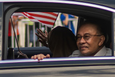 Malaysia&rsquo;s Prime Minister Anwar Ibrahim (right) and his wife Wan Azizah Wan Ismail arrive during the 69th National Day celebrations in Malaysia's administrative capital Putrajaya on Aug. 31, 2026.