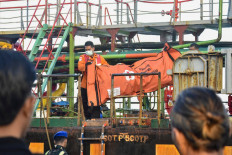 Rescue personnel carry a body bag containing clothes of victims of the Virgo Transport 8 passenger ferry on Sept. 14 at the port in Banjarmasin, South Kalimantan. The vessel capsized on Sept. 13 carrying 213 passengers and 30 crew while en route from Banjarmasin to Surabaya.