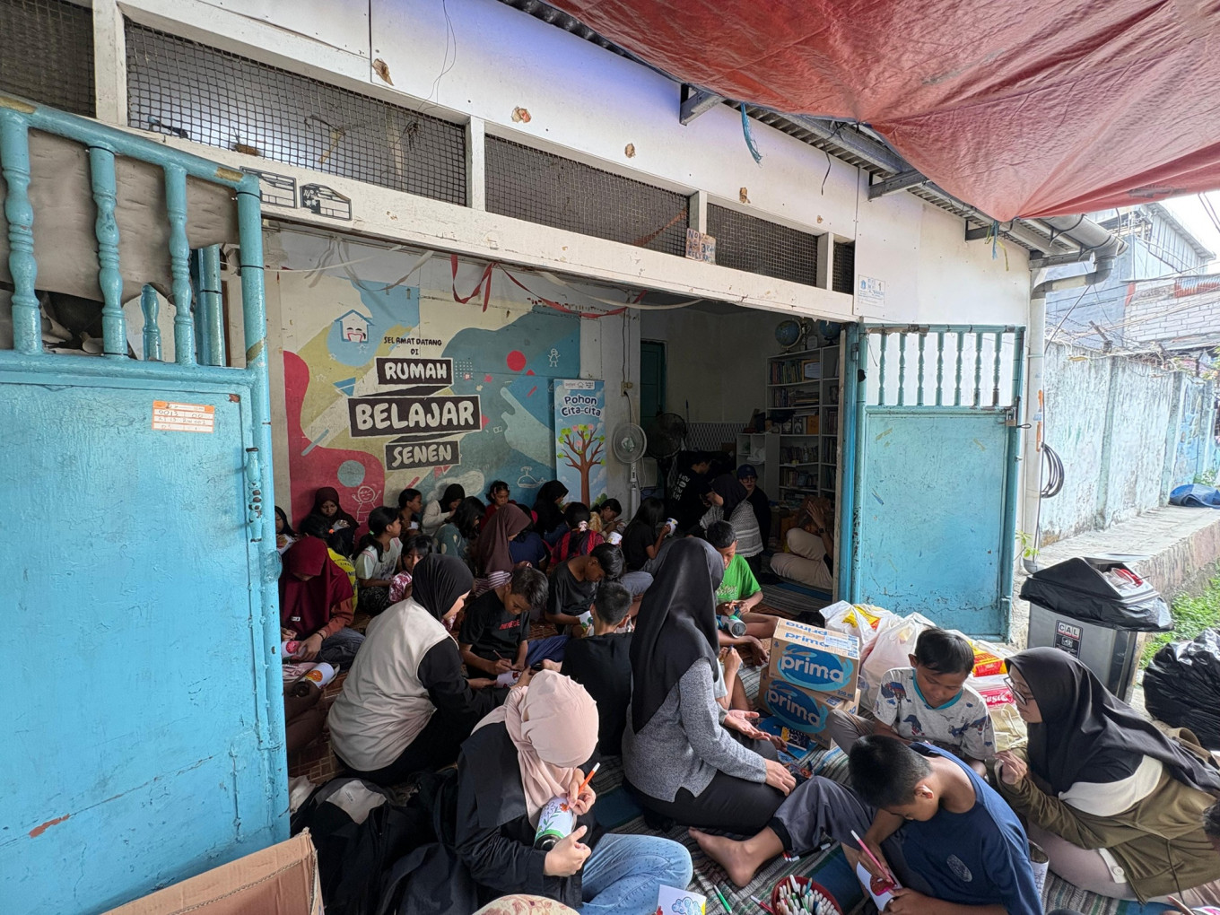 Extra lesson: Children in fourth to sixth grade do coloring activities with volunteers during the noon session at Rumah Belajar Senen in Senen, Central Jakarta, on July 18, 2026.