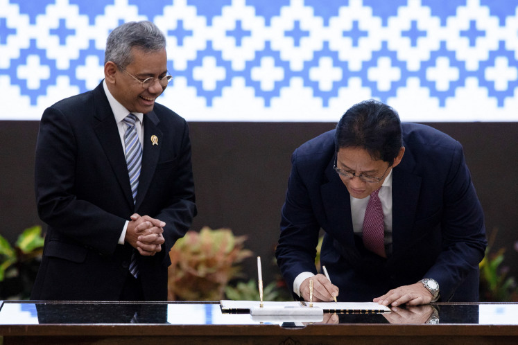 Indonesia's newly appointed Finance Minister Suahasil Nazara reacts as outgoing Finance Minister Purbaya Yudhi Sadewa signs a document, during a handover ceremony at the Finance Ministry in Jakarta, September 15, 2026.