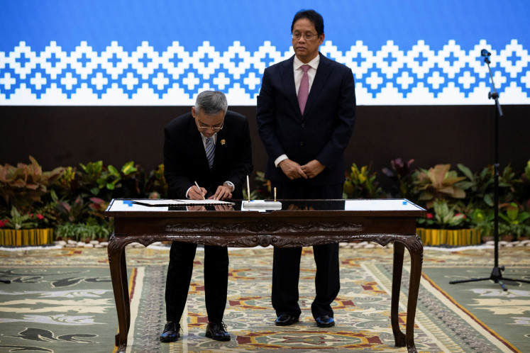 Newly appointed Finance Minister Suahasil Nazara (left) signs a document as his predecessor Purbaya Yudhi Sadewa observes on Sept. 15, 2026, during a handover ceremony at the Finance Ministry in Central Jakarta.