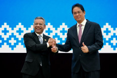 Newly appointed Finance Minister Suahasil Nazara (left) shakes hands with outgoing finance minister Purbaya Yudhi Sadewa during a handover ceremony on Sept. 15 at the Finance Ministry in Jakarta.