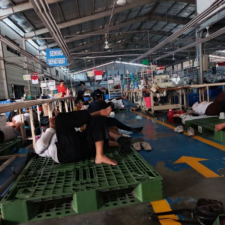 PT Ghim Li Indonesia's workers, who have been abandoned by the management, lie down in the company's factory on Monday to safeguard company assets, such as sewing machines, at the factory's Sewing Department in the Tunas Industrial Area, Batam city in Riau Islands. The Ghim Li management team abandoned the workers after failing to pay August wages.