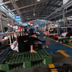 PT Ghim Li Indonesia's workers, who have been abandoned by the management, lie down in the company's factory on Monday to safeguard company assets, such as sewing machines, at the factory's Sewing Department in the Tunas Industrial Area, Batam city in Riau Islands. The Ghim Li management team abandoned the workers after failing to pay August wages.