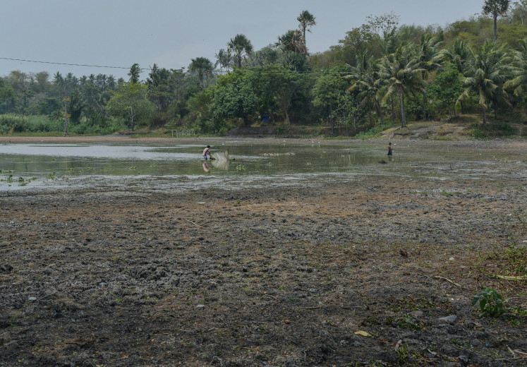 Residents fish at Lake Sibili, where water levels have receded in Palu, Central Sulawesi, on Thursday, Sept. 17, 2026. 