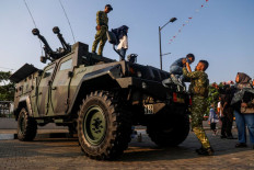 Real wheels: A member of the Indonesian Army (right) helps a boy down from a Komodo armored vehicle by state arms maker PT Pindad on Aug. 24, 2026, during a military exhibition at Living World Grand Wisata in Bekasi, West Java.