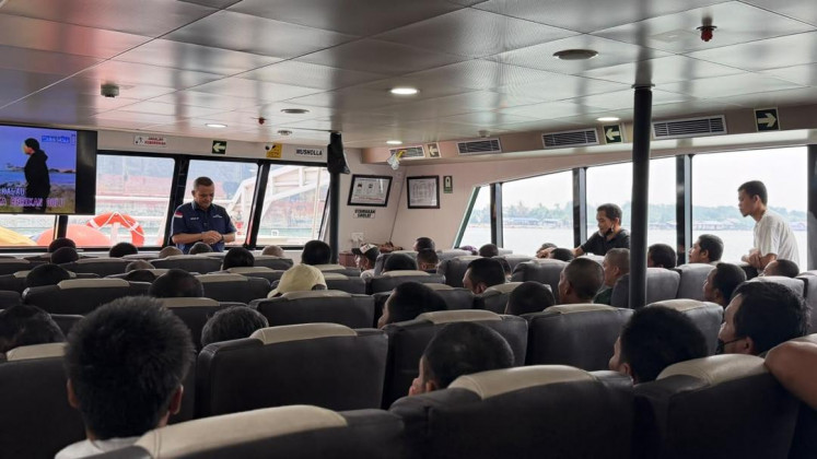 An official from the Indonesian Consulate General in Johor Bahru (left) speaks to Indonesians being repatriated on board a ferry during a trip from Pasir Gudang international ferry terminal in Johor Bahru to Batam Center international ferry terminal in Batam city, Riau Islands, on Sept. 15, 2026. Malaysia deported 150 Indonesian who had completed their immigration administration process for overstaying and working illegally.