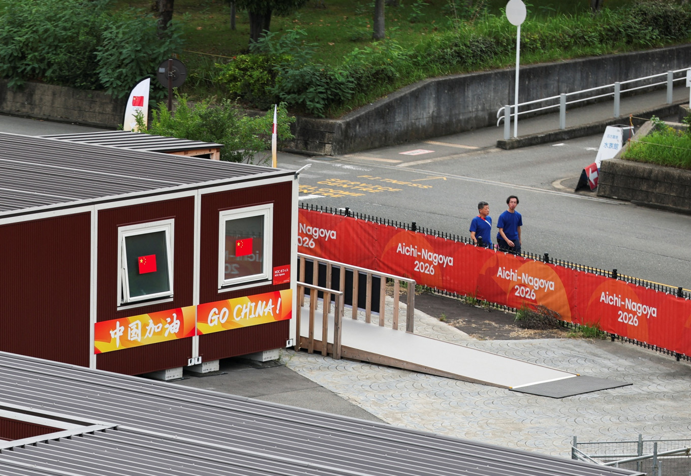 People walk past wooden container units built to house athletes, including those for the Chinese athletes, ahead of the Aichi-Nagoya 2026 Asian Games in Nagoya, Japan, on Sept. 15, 2026.