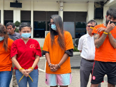 WSB (center), a Singaporean national who has been detained for attempting to smuggle 40 vape cartridges containing the illicit drug etomidate, is presented alongside 14 other narcotics suspects on Sept. 17, 2026, at the Batam, Rempang and Galang (Barelang) Police headquarters in Batam, the Riau Islands.
