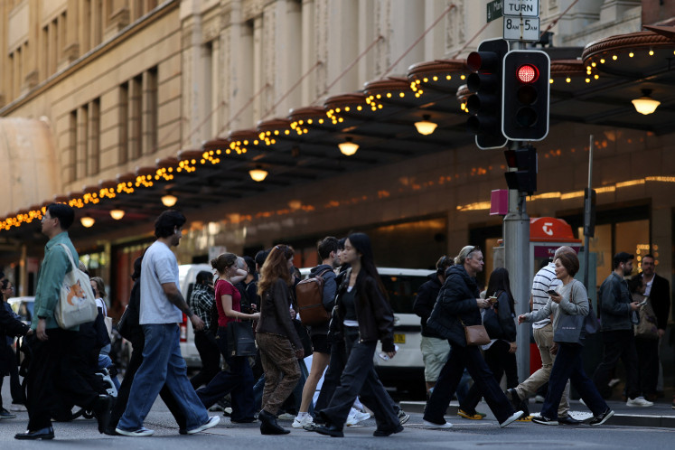 People cross the street near Pitt Street Mall in Sydney, Australia, September 17, 2026.
