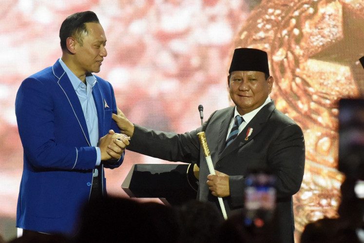 Democratic Party chairman Agus Harimurti Yudhoyono (left) hands a command stick to President Prabowo Subianto in Jakarta on Feb. 25, 2025, during the party&rsquo;s sixth congress.