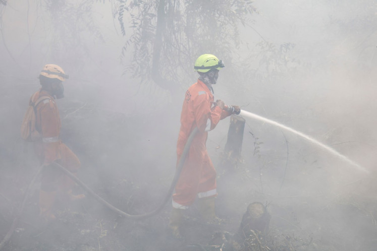 Firefighters extinguish forest and land fires in Banjar, South Kalimantan, on September 21, 2026. Toxic haze has shrouded parts of Indonesia, Malaysia and Singapore for weeks as Jakarta struggles to contain fires that have scorched large tracts of Borneo and Sumatra, with the smoke drifting across the region.