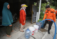 South Jakarta Disaster Mitigation Agency (BPBD) personnel fill residents&rsquo; buckets with water on Sept. 16 in West Cilandak, South Jakarta. BPBD South Jakarta, in collaboration with city-owned water company PAM Jaya, distributed free clean water to residents affected by water shortages caused by drought, which has left water supplies cloudy and reduced availability. 