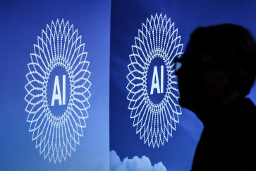 A person is silhouetted next to the logo of the first Global Dialogue on AI Governance, in Geneva on July 6, 2026. UN secretary-general Guterres called for a global governance system to shape artificial intelligence for the good of humanity, warning against allowing the technology itself to &ldquo;vibe-code&ldquo; our future.