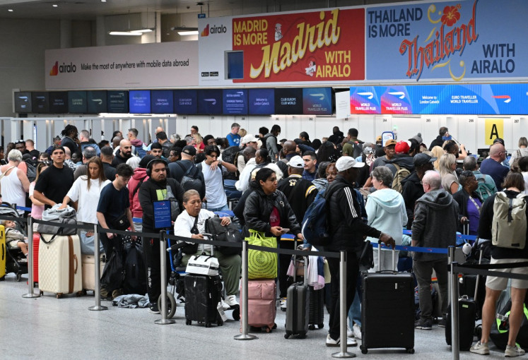 Passengers stand with their luggage as they queue to check-in at the South Terminal of London Gatwick airport near Crawley, southern England on September 9, 2026, following the second day of major disruption due an issue affecting the NATS air traffic control systems. UK travelers faced more misery on September 9, with more than 150 flights scrapped across the country, as Britain's air traffic control service scrambled to recover from a technical glitch that sparked chaos.
