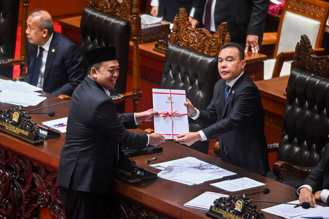Agrarian and Spatial Planning Minister Nusron Wahid (left) hands over a copy of the government's response to the agrarian reform bill to House of Representatives Deputy Speaker Sufmi Dasco Ahmad (right) during a plenary session at the House on Sept. 22, 2026.
