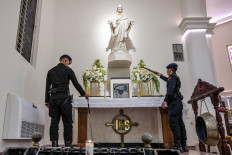 Police officers conduct a security check at the Sacred Heart of Jesus Cathedral Church, known locally as the &ldquo;Hati Kudus Yesus&ldquo; church, on Christmas Eve in Surabaya, East Java, on Dec. 24, 2025.