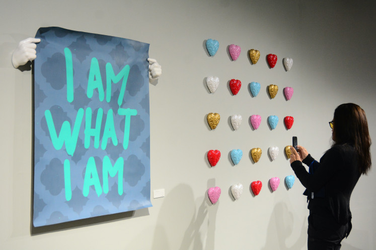 Intimate reflection: Filmmaker Jay Subiakto uses a mobile phone to document an artwork by Abell Octovan on Sept. 18, 2026, during the opening of the multidisciplinary artist&rsquo;s debut solo exhibition, Am I An Artist, at JPLive! Space at The Jakarta Post in Tanah Abang, Central Jakarta.