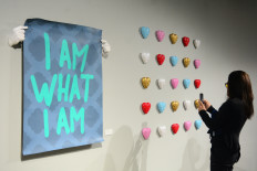 Intimate reflection: Filmmaker Jay Subiakto uses a mobile phone to document an artwork by Abell Octovan on Sept. 18, 2026, during the opening of the multidisciplinary artist&rsquo;s debut solo exhibition, Am I An Artist, at JPLive! Space at The Jakarta Post in Tanah Abang, Central Jakarta.