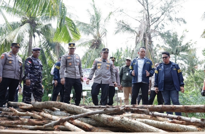 Riau Police chief Insp. Gen. Herry Heryawan (third right) listens to an explanation from Special Crimes Investigation (Reskrimsus) Directorate chief Sr. Comr. Ade Kuncoro (second right) on Wednesday at a mangrove charcoal production center on Rupat Island in Bengkalis regency, Riau. Detectives from the Reskrimsus Directorate thwarted on Sept. 14 an effort to smuggle mangrove charcoal from Rupat Island to Batu Pahat in Johor, Malaysia. 