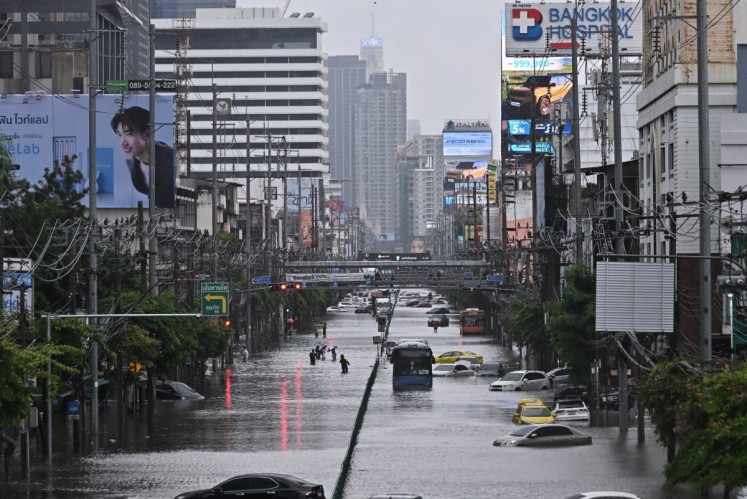 People walk along a flooded Petchaburi road in Bangkok, Thailand on Sept. 26, 2026. Bangkok authorities declared a flood disaster across the Thai capital after almost 48 hours of heavy rain left canals full, roads submerged and residents wading through deep water.