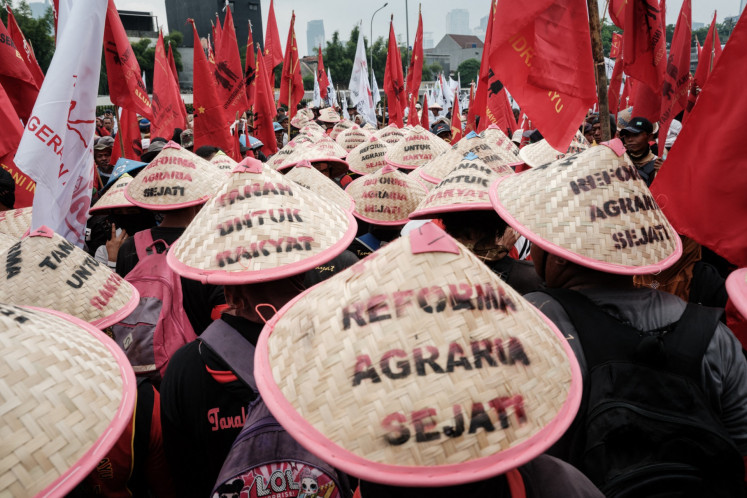 Farmers wearing hats reading &ldquo;True agrarian reform&ldquo; protest against what they described as the government's failure to implement agrarian reforms as they commemorate National Farmers Day in front of the Senayan Legislative Complex in Central Jakarta on Sept. 24, 2024.
