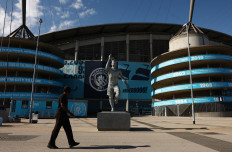 A man walks in front of the statue of former Manchester City player Sergio Aguero outside the Etihad Stadium in Manchester, Britain, on Sept. 26, 2026. 