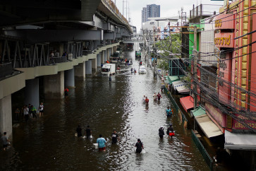 People navigate through a flooded area in Bangkok, Thailand, September 28, 2026.