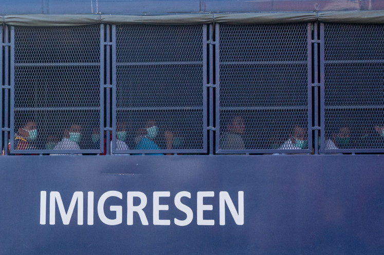 An immigration truck believed to be carrying Myanmar migrants from Malaysia back to their homeland, is seen heading towards the Naval base in Lumut, outside Kuala Lumpur on February 23, 2021.