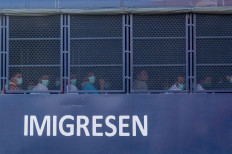An immigration truck believed to be carrying Myanmar migrants from Malaysia back to their homeland, is seen heading towards the Naval base in Lumut, outside Kuala Lumpur on February 23, 2021.