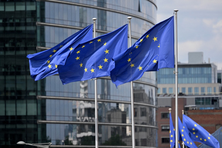 This photograph shows European flags outside the EU headquarters in Brussels on May 6, 2025.