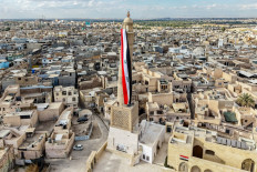 A giant Iraqi flag hangs off the reconstructed 12th century &ldquo;Hadba&ldquo; leaning minaret at the historic Great Mosque of al-Nuri in the old city of Mosul on September 29, 2026 as Iraq marks the withdrawal of the US-led anti-Islamic State coalition forces from the country. After more than a decade, the US-led coalition is ending its mission in Iraq, having helped save the country from jihadists but causing persistent friction in the country. Iraqi Prime Minister Ali al-Zaidi declared that October 1, the day following the coalition's departure, should be celebrated as Sovereignty Day.