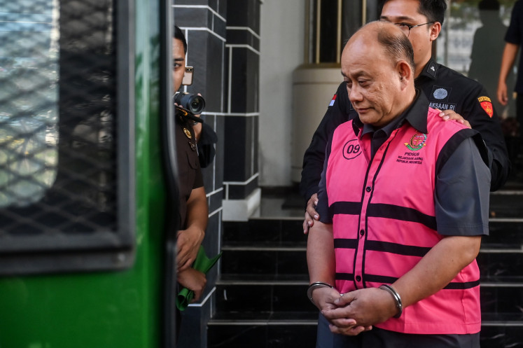 Former National Nutrition Agency (BGN) head Dadan Hindayana walks toward a prisoner van on Tuesday after an interrogation at the Central Jakarta Prosecutor's Office in Jakarta. The Attorney General's Office (AGO) suspects Dadan and former deputies of the agency of being involved in corruption pertaining to the free nutritious meal program.