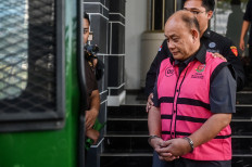 Former National Nutrition Agency (BGN) head Dadan Hindayana walks toward a prisoner van on Tuesday after an interrogation at the Central Jakarta Prosecutor's Office in Jakarta. The Attorney General's Office (AGO) suspects Dadan and former deputies of the agency of being involved in corruption pertaining to the free nutritious meal program.