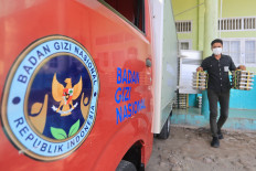 A worker carries meal trays under the free nutritious meal program on Sept. 21 to be disbursed to students at the state-run Islamic elementary school MIN 11 West Aceh, Aceh.