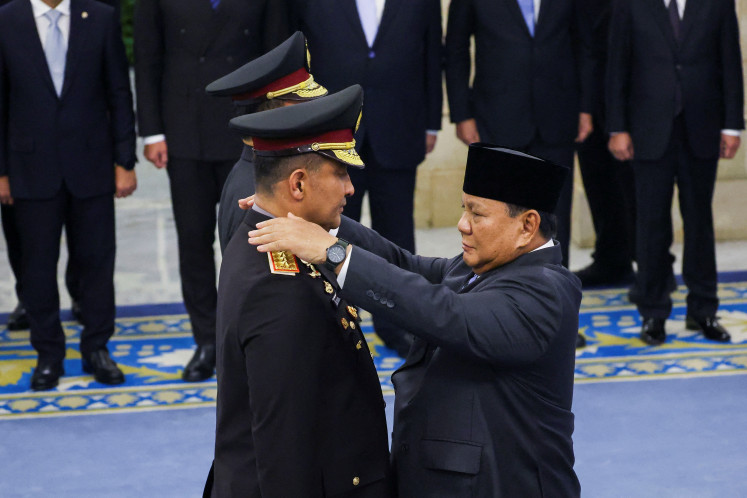 Indonesian President Prabowo Subianto attaches a rank insignia to the uniform of newly appointed National Police Chief Suyudi Ario Seto on Thursday during his inauguration at the State Palace in Jakarta.
