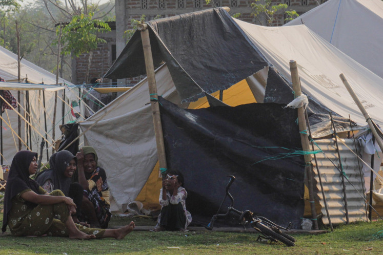 Several women sit near a makeshift tent at a communal evacuation shelter in Nagekeo regency, East Nusa Tenggara (NTT) on Sept. 29, 2026. 