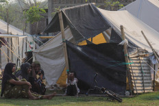 Several women sit near a makeshift tent at a communal evacuation shelter in Nagekeo regency, East Nusa Tenggara (NTT) on Sept. 29, 2026. 