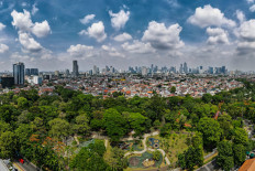 The skyline of downtown Jakarta appears in the distance on Nov. 1, 2022, beyond the lush greenery of Tebet Eco Park in Tebet, South Jakarta.