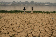 Two women stand on the receded bank of the Kahayan River on Sept. 15 in Palangka Raya, Central Kalimantan.
