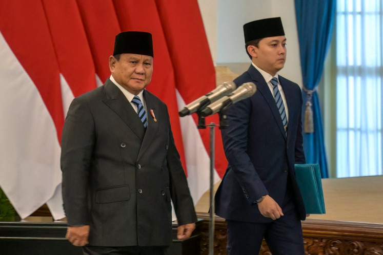 President Prabowo Subianto (left) walks past the podium ahead of a swearing-in ceremony for newly appointed cabinet ministers during a cabinet reshuffle at the State Palace in Jakarta on October 1, 2026.