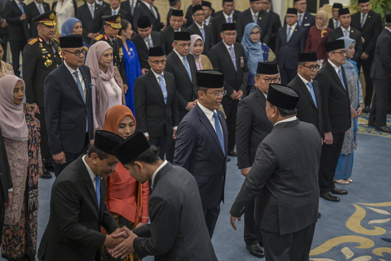 President Prabowo Subianto (front right) and Vice President Gibran Rakabuming Raka (front left) congratulate and shake hands on Oct. 1, 2026, with incoming Cabinet members following a reshuffle, at the State Palace in Central Jakarta. 