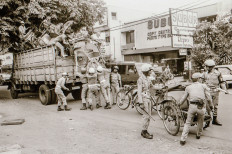 On Oct. 6, 1987, during a raid on Jl. Wolter Monginsidi in South Jakarta, officers seized and loaded pedicabs onto trucks as traffic whizzed by, seemingly oblivious to their removal.